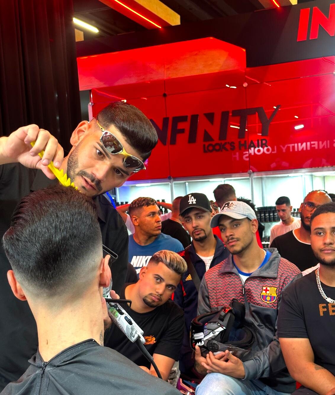 Roni demonstrando um corte diante de outros barbeiros